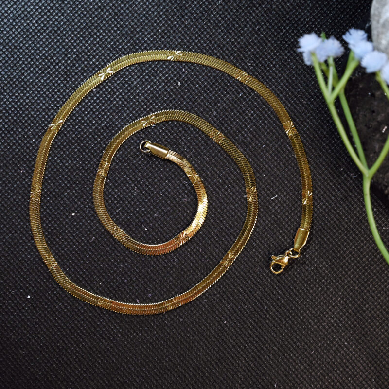 Flat snake gold necklace with embossed star detail design.