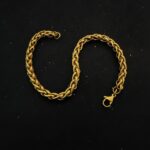 High-polish gold wheat link bracelet on a mans wrist