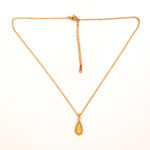 Gold teardrop necklace with sunburst center and crystal halo