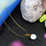 Minimalist round white stone pendant on gold necklace for women.