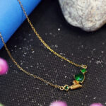 Dainty gold chain with emerald heart and gemstone pendant