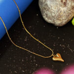 AuraSpark 18K gold puffy heart pendant on beaded snake chain.