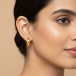 Pair of chunky high-polish gold huggie hoops for women.