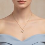 Gold AuraSpark necklace with iridescent crystal and purple enamel.