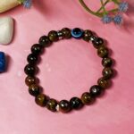 Brown Tiger Eye stone bracelet with blue evil eye charm.